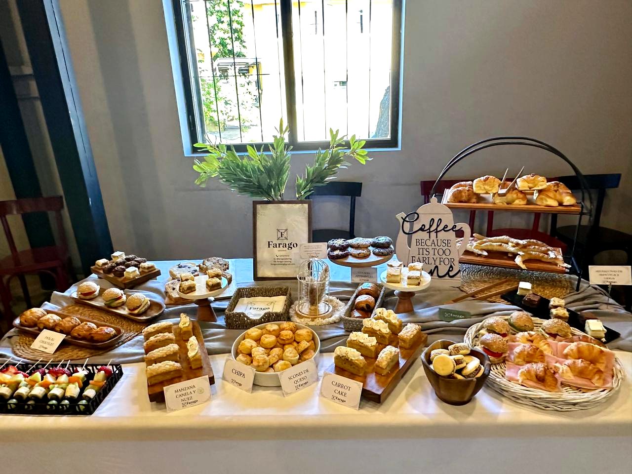 Mesa de desayuno con pastelería propia y carteles de cada variedad